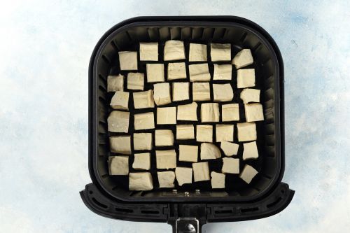 step 5: Place the tofu cubes in the air fryer. Cook for 10 minutes. Flip sides, then cook for another 5 minutes.