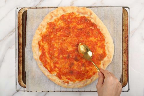 Step 8: Brush the tomato sauce on the crust.